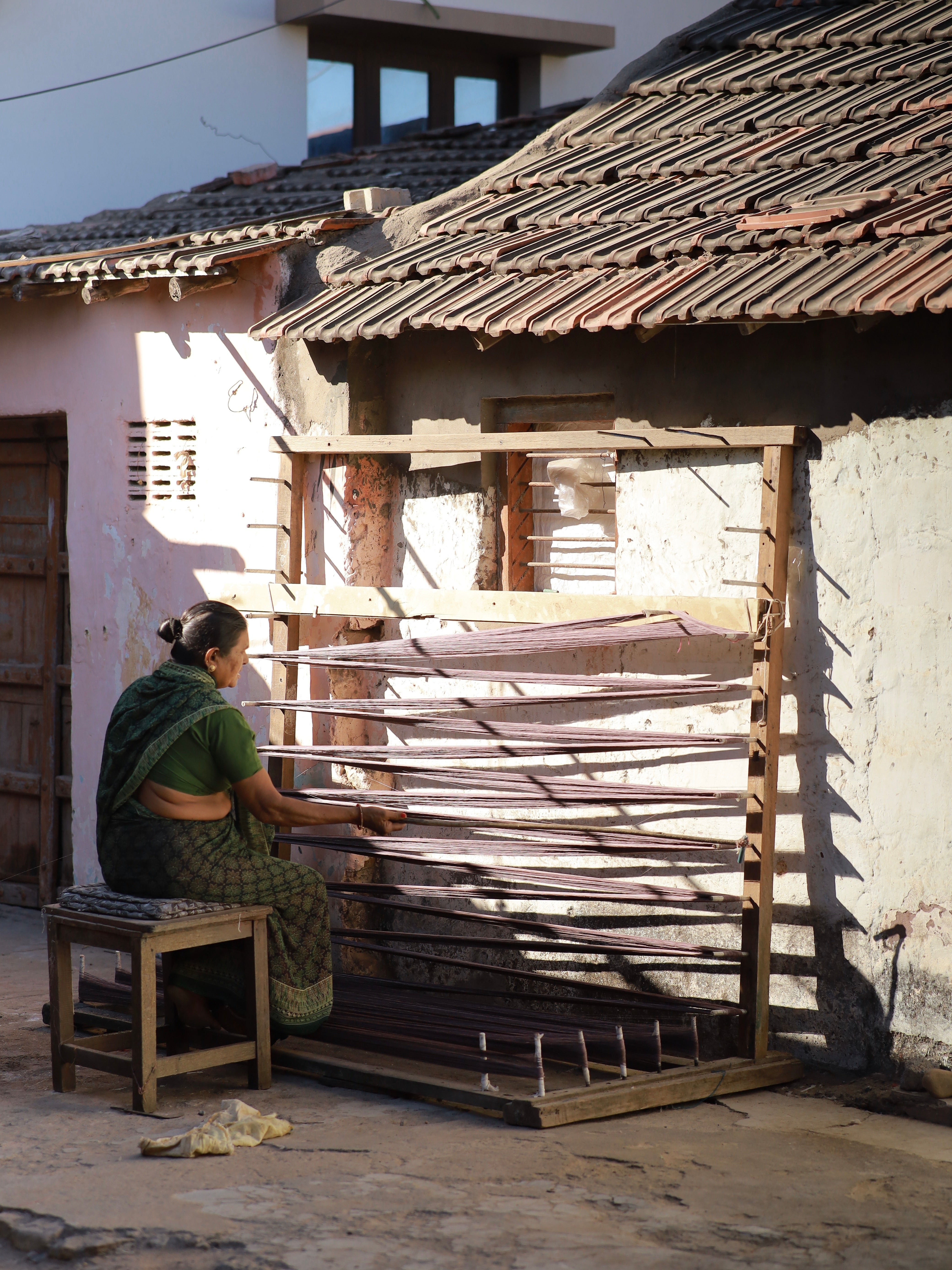 Our woman artisan winding yarn by hand in the warm afternoon light—preserving generational weaving wisdom.